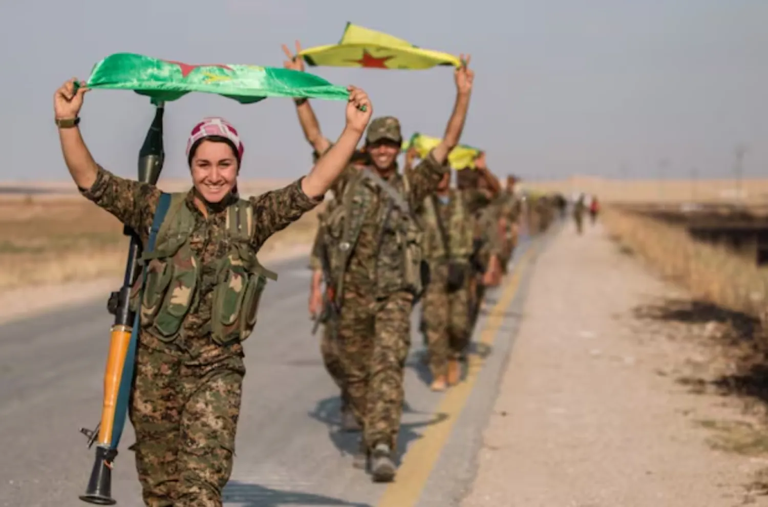 Kurdish fighters gesture while carrying their parties' flags in Tel Abyad of Raqqa governorate after they said they took control of the area June 15, 2015. REUTERS/Rodi Said/Files 