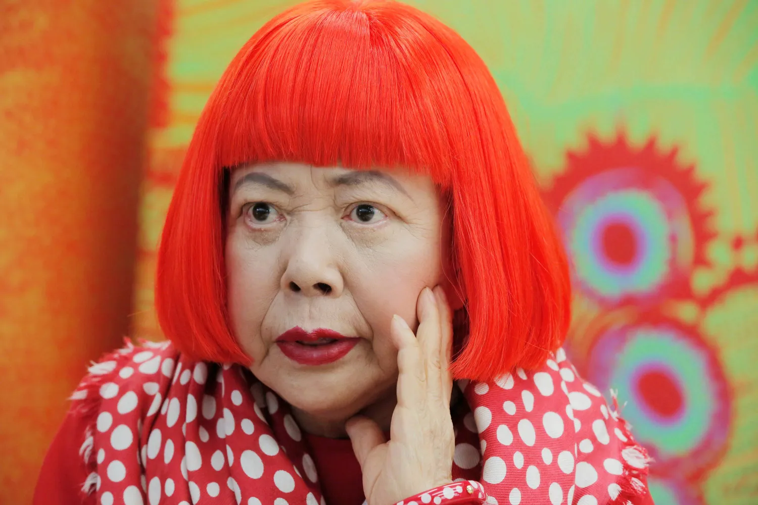  Japanese avant-garde artist Yayoi Kusama, wearing a bright red wig and a Louis Vuitton polka dot scarf, speaks during an interview at her studio in Tokyo, on Aug. 1, 2012. (AP) 