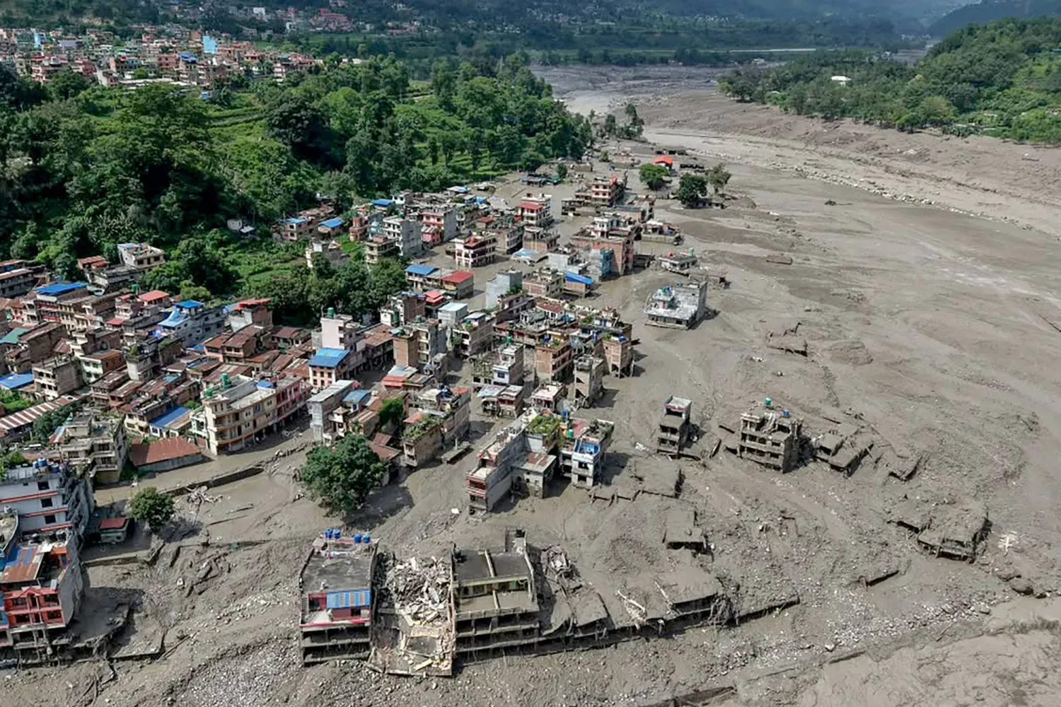 Nepal'in kuzeyindeki Nuwakot bölgesinde sel sularının etkisiyle evlerin bir kısmı sular altında kaldı (AFP)