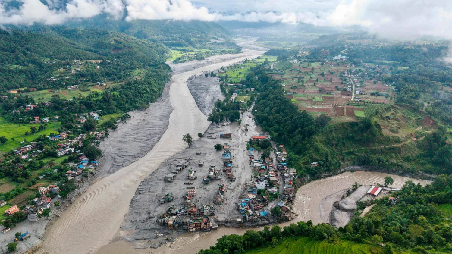 An aerial view shows houses lying deluged in sludge after flash floods at Devighat, Bidur Municipality, along the confluence of the Trishuli and Tadi rivers in Nepal's Nuwakot district on August 27, 2026. (AFP) 