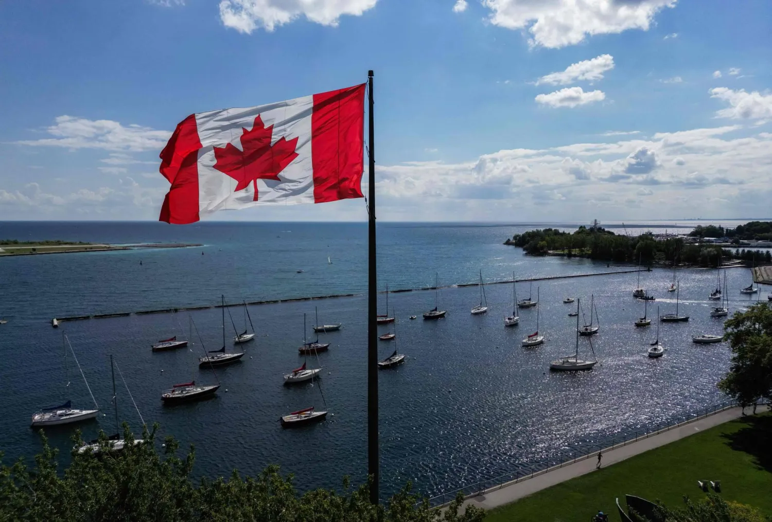 A Canadian flag flies along the waterfront of Lake Ontario, in Toronto, Ontario, Canada, on August 27, 2026. (AFP) 