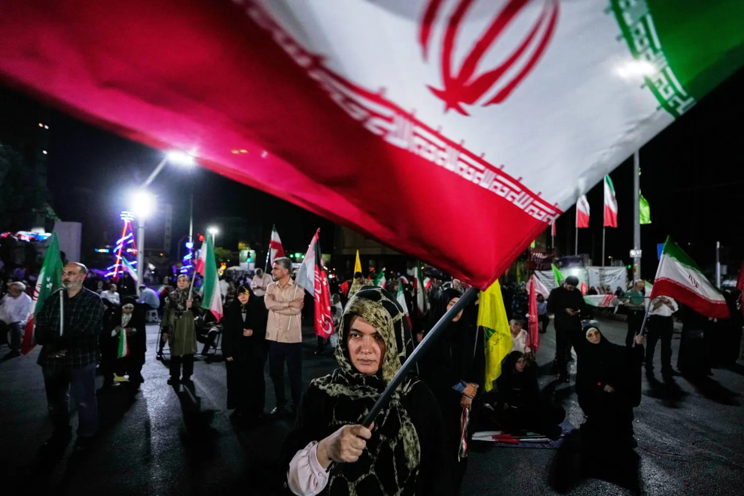  A pro-government demonstrator waves an Iranian flag during a gathering in a square in Tehran, Wednesday, Aug. 26, 2026. (AP) 