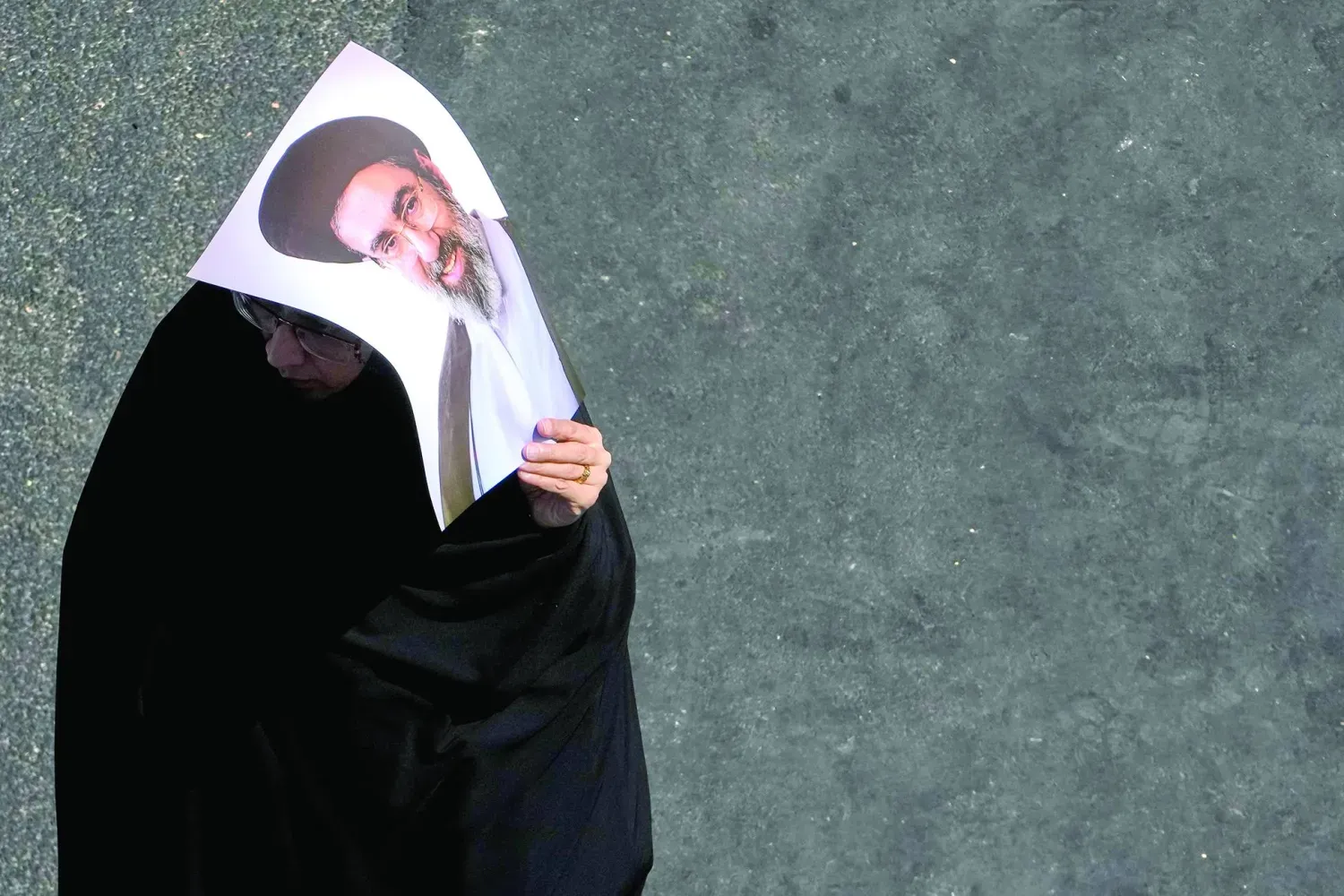 Geçtiğimiz salı günü Tahran’da düzenlenen erbain töreninde Mücteba Hamaney’in resmini taşıyan İranlı bir kadın (AP)