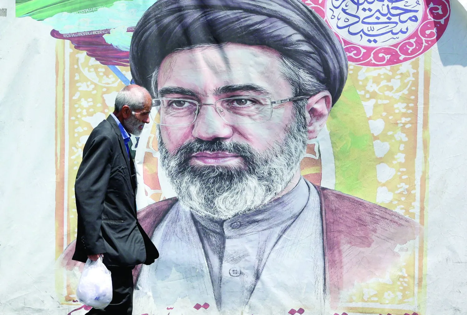 An Iranian man walks past a poster of Iranian supreme leader Mojtaba Khamenei in a street in Tehran, Iran, 18 June 2026. EPA/ABEDIN TAHERKENAREH 