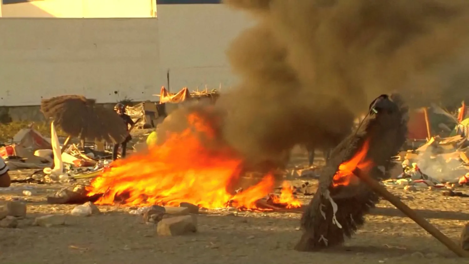 Smoke and flames rise as Ceuta residents destroy a migrant camp by the beach in the Spanish North African enclave on August 27, 2026. (Reuters)