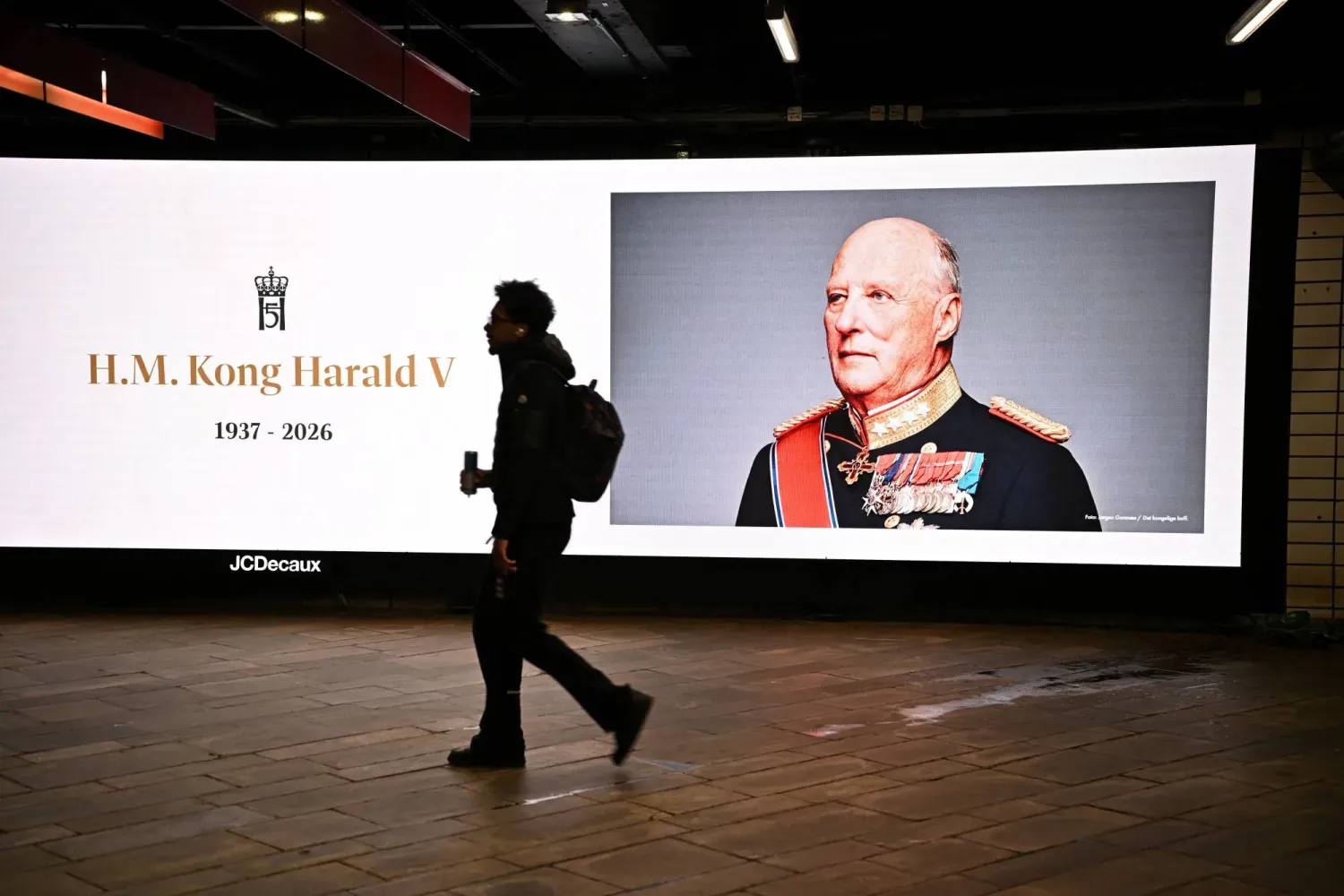 Norveç'in merhum Kralı Harald'ın portresinin önünden geçen bir adam (Reuters)