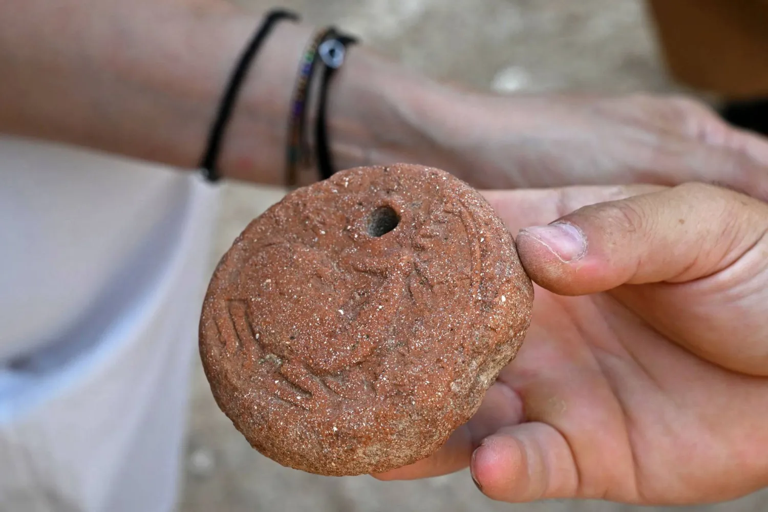 An archaeologist displays an artifact found from an archaeological site in the northern coastal Lebanese town of Batroun on August 14, 2026. (AFP) 