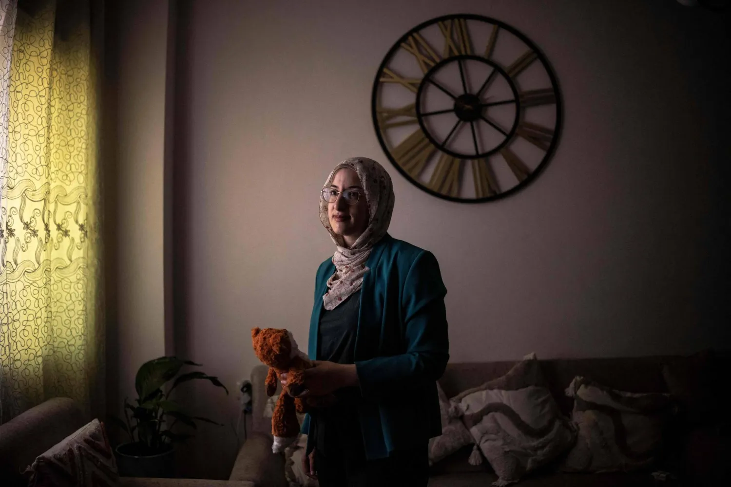 This photo taken on August 7, 2026 shows Palestinian woman Dania Abu Haikal, mother of seven-month-old Sam, who was killed by Israeli forces whilst sitting on his mother's lap in the car, stands for portrait while holding her late son's teddy bear in Bethlehem, in the Israeli-occupied West Bank. (AFP)