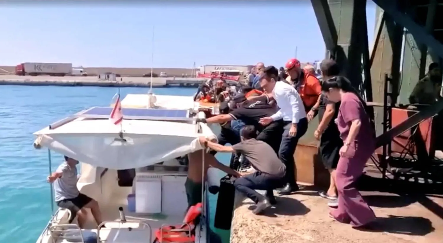 قوارب الإنقاذ تنقل الركاب إلى الشاطئ من قارب انقلب بشمال قبرص في لقطة مأخوذة من مقطع فيديو (رويترز)