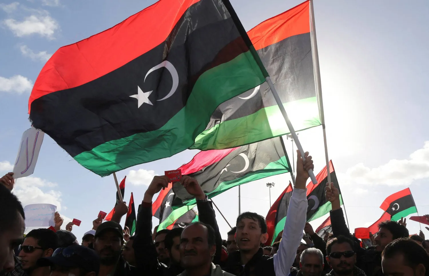 People wave Libyan flags during a demonstration in Benghazi February 7, 2014. (Reuters) 