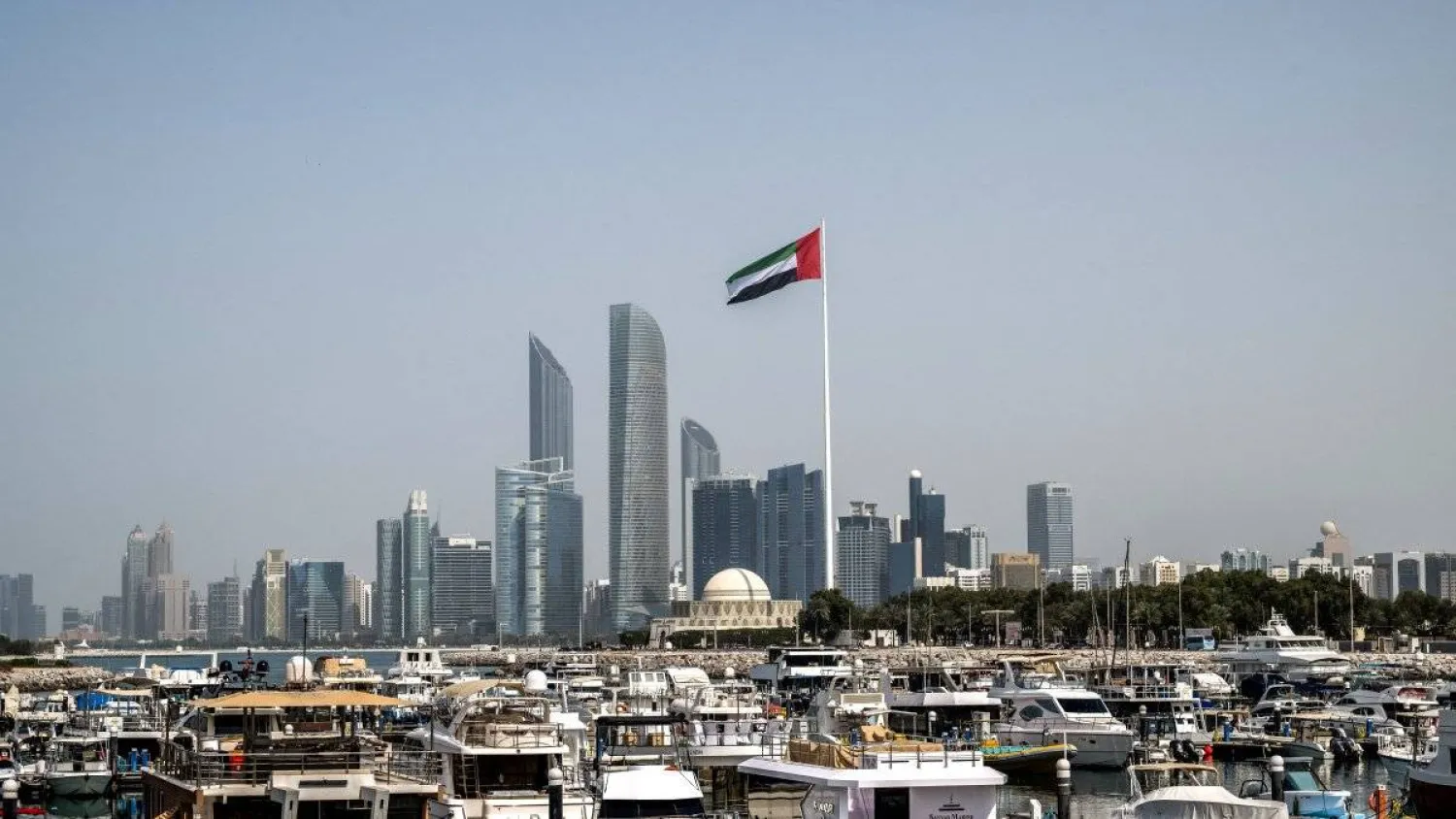 The United Arab Emirates flag flutters against the backdrop of the Abu Dhabi skyline, March 1, 2026. (AFP)