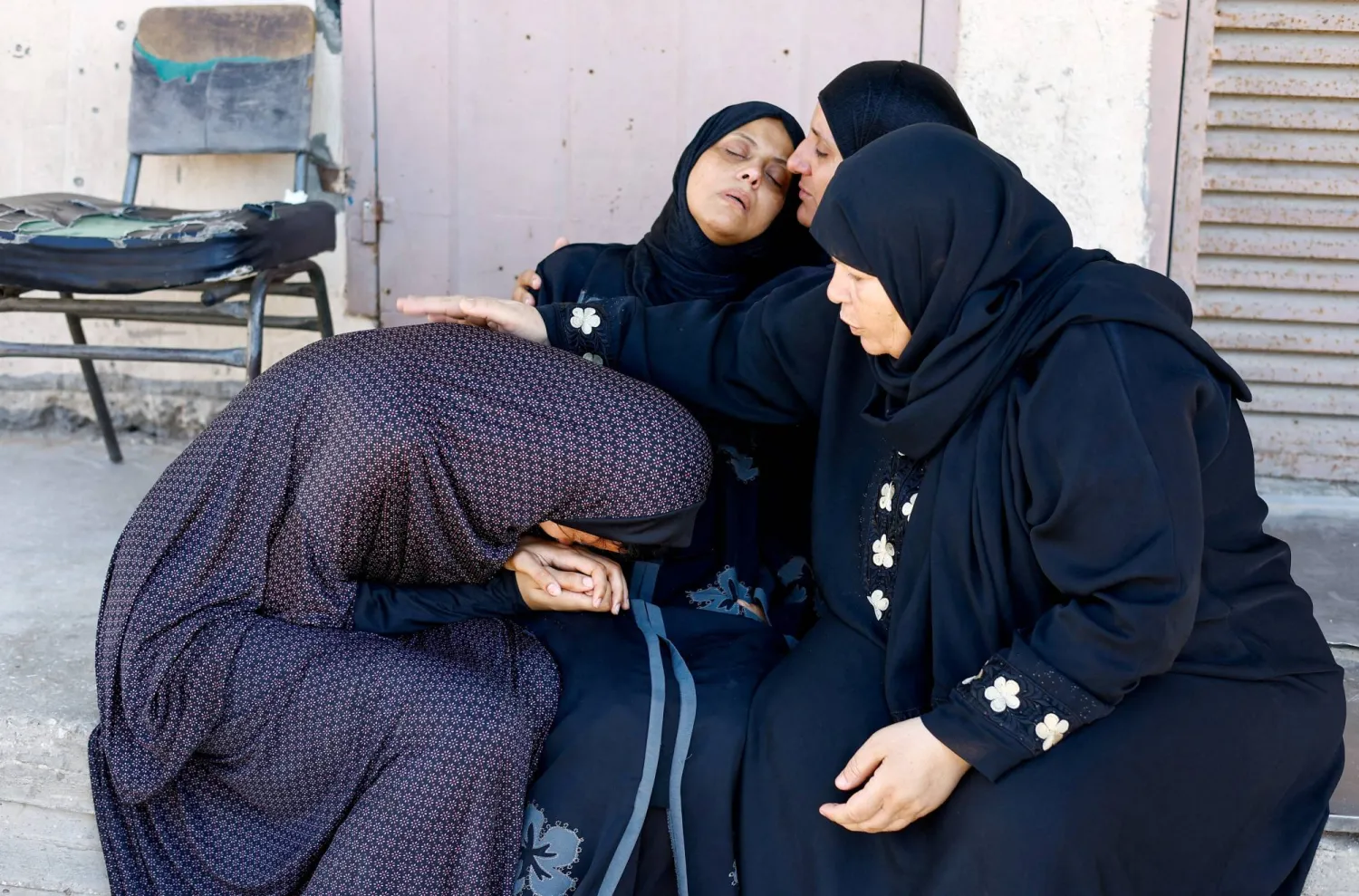أقارب قتلى فلسطينيين في مستشفى شهداء الأقصى بدير البلح بمدينة غزة (رويترز)