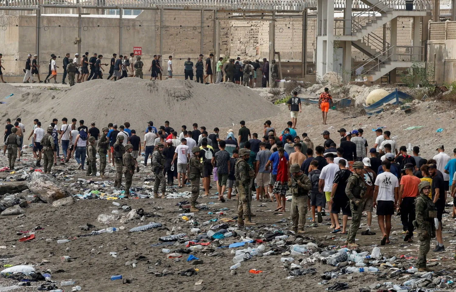 مواطنون يسيرون باتجاه الحدود مع المغرب مغادرين إسبانيا وسط عمليات عبور جماعية للمهاجرين سيراً على الأقدام وبحراً من المغرب إلى الأراضي الإسبانية في سبتة 31 يوليو 2026 (رويترز)