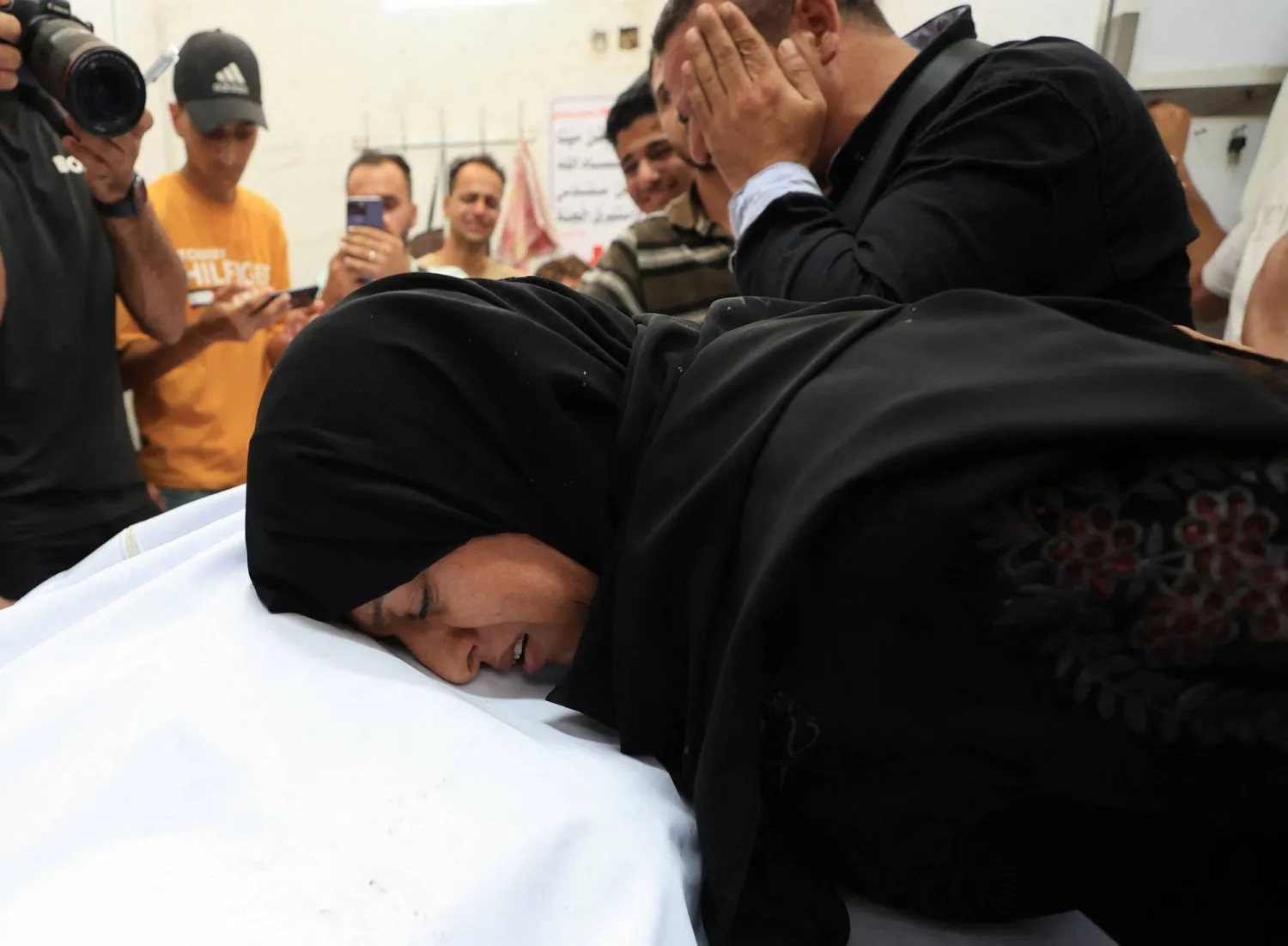 فلسطينيون متأثرون خلال تشييع أحد قتلى الغارات الإسرائيلية في مدينة غزة الاثنين (رويترز)