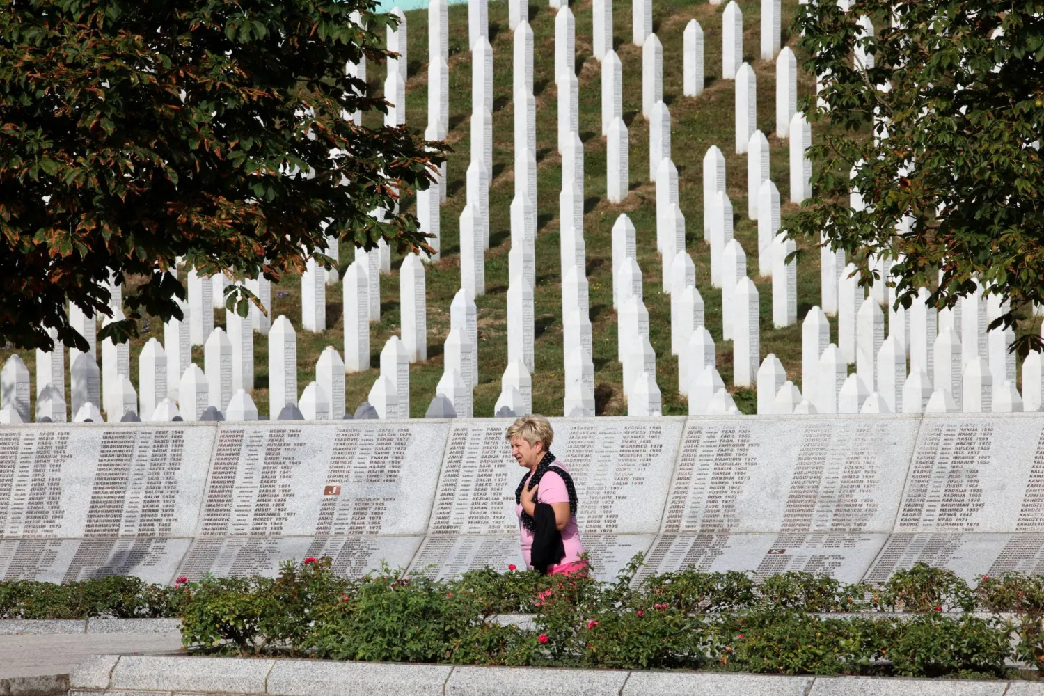 A Bosnian woman looks at the names of victims at the memorial cemetery where the victims of the Srebrenica genocide are buried, following the death of Bosnian Serb Ratko Mladic, former general convicted of Bosnia genocide, in Potocari, Bosnia and Herzegovina, August 28, 2026. (Reuters)