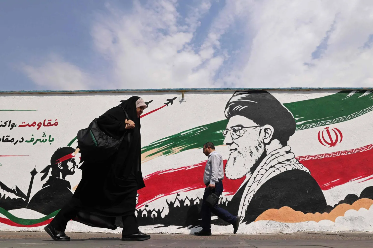 مشاة يسيرون أمام جدارية للمرشد الإيراني الراحل علي خامنئي على طول أحد شوارع وسط طهران 31 أغسطس 2026 (أ.ف.ب)