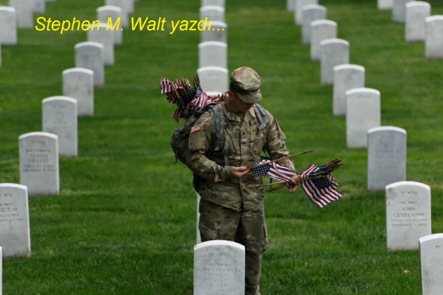 Bir ABD askeri, Virginia'daki Arlington Ulusal Mezarlığı'nda, Anma Günü hazırlıkları kapsamında bir mezara Amerikan bayrağı yerleştiriyor, 25 Mayıs 2017 (AFP)