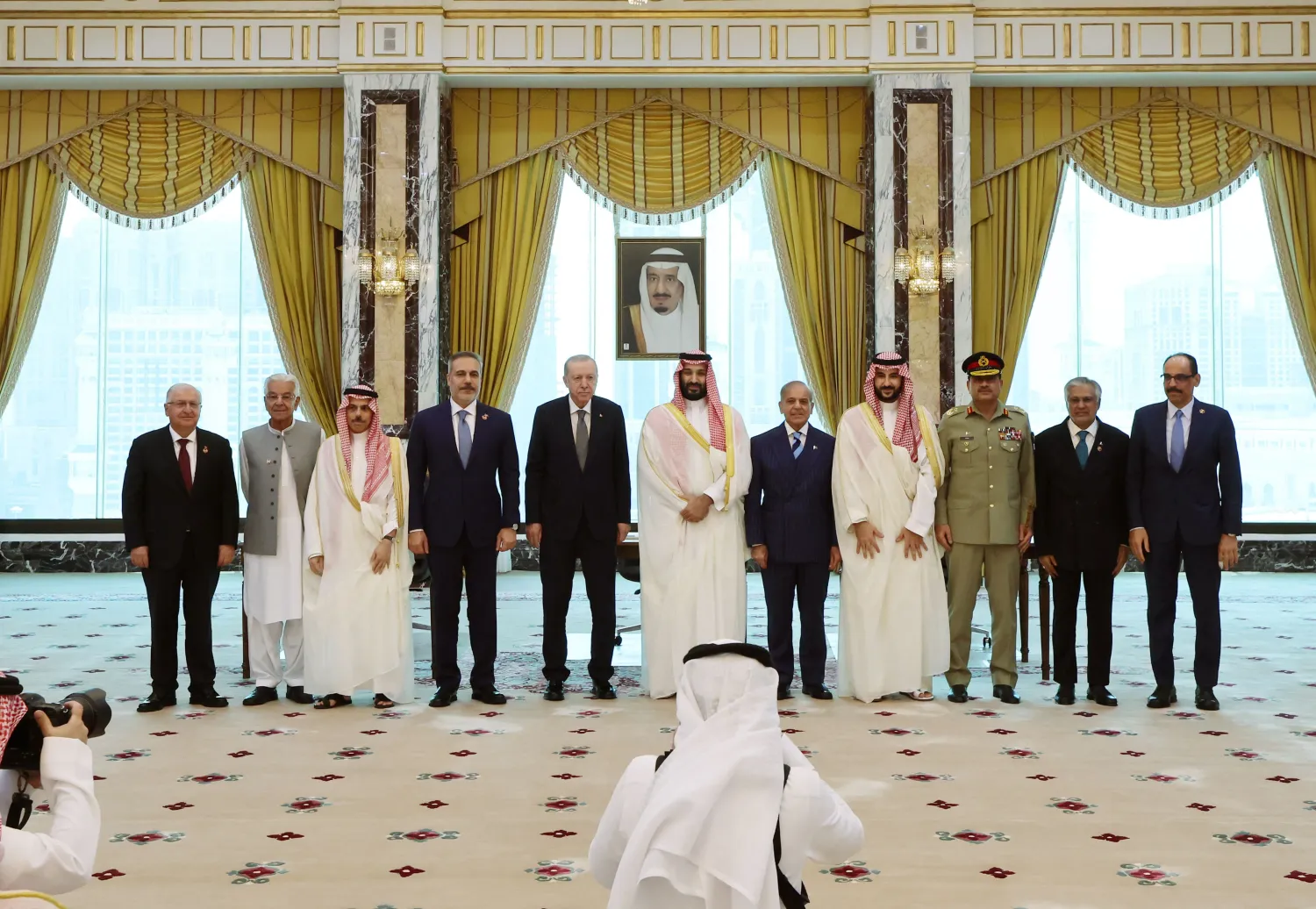 This handout photograph taken and released by Turkish Presidency Press Office on August 7, 2026, shows Minister of Foreign Affairs of Saudi Arabia Prince Faisal bin Farhan al-Saud (3rd L), Turkish Foreign Minister Hakan Fidan (4th L), Turkish President Recep Tayyip Erdogan (5th L), Saudi Crown Prince Mohammed bin Salman (C), Pakistani Prime Minister Shehbaz Sharif (5th R), Saudi Defense Minister Prince Khalid bin Salman al-Saud (4th R), and their delegations as they pose after signing a trilateral joint defense agreement in Makkah, Saudi Arabia. (Photo by Handout / Turkish Presidency Press Office / AFP) 