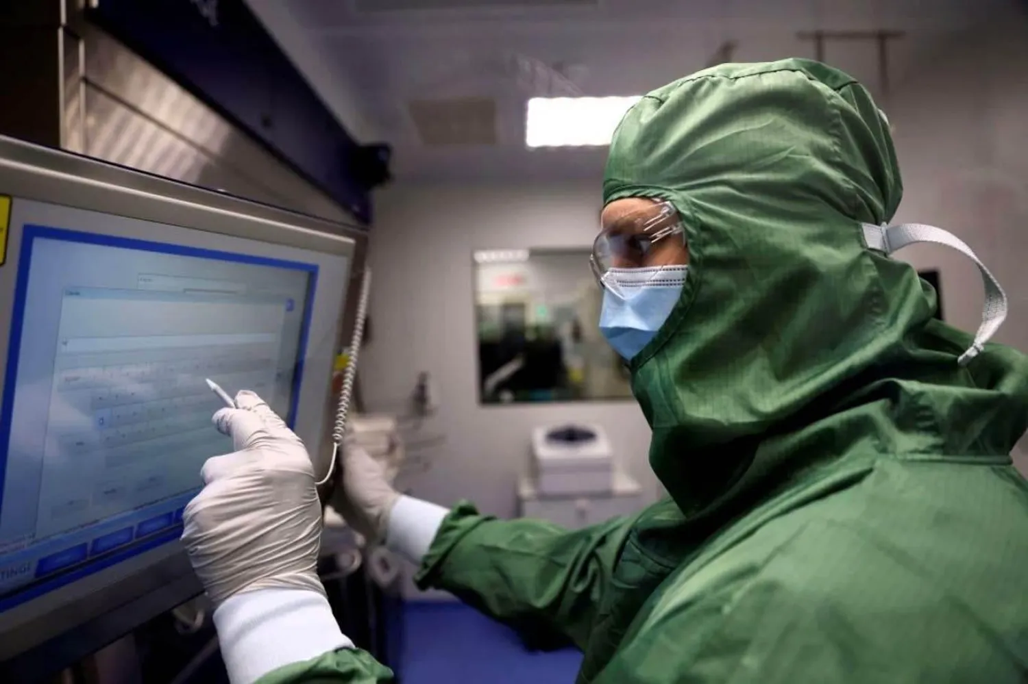 Paris'teki Fransız biyofarmasötik şirketi Cellectis'in laboratuvarındaki laboratuvar teknisyenleri, kanser tedavileri için CAR-T hücreleri ve RNA üretmek üzere 23 Eylül 2021'de bir makinede çalışıyor (Thomas Coex/AFP)