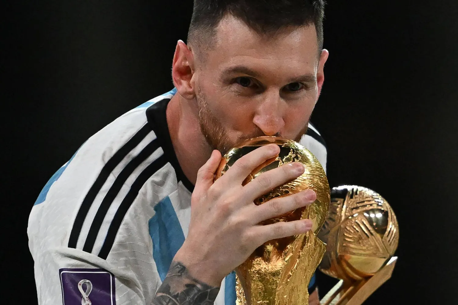Argentina's captain and forward #10 Lionel Messi kisses the FIFA World Cup Trophy during the trophy ceremony after Argentina won the Qatar 2022 World Cup final football match between Argentina and France at Lusail Stadium in Lusail, north of Doha on December 18, 2022. (AFP)