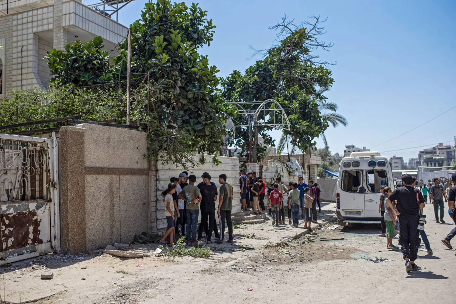 فلسطينيون قرب منزل مسؤول أمني في «حماس» تعرض لهجوم إسرائيلي أسفر عن اختطافه يوم الثلاثاء (إ.ب.أ)