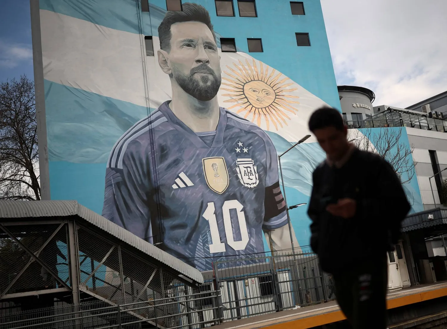 A commuter walks past a mural of Argentine soccer legend Lionel Messi, on the day he announced his retirement from the national team, at the Villa del Parque train station, in Buenos Aires, Argentina, August 31, 2026. (Reuters)