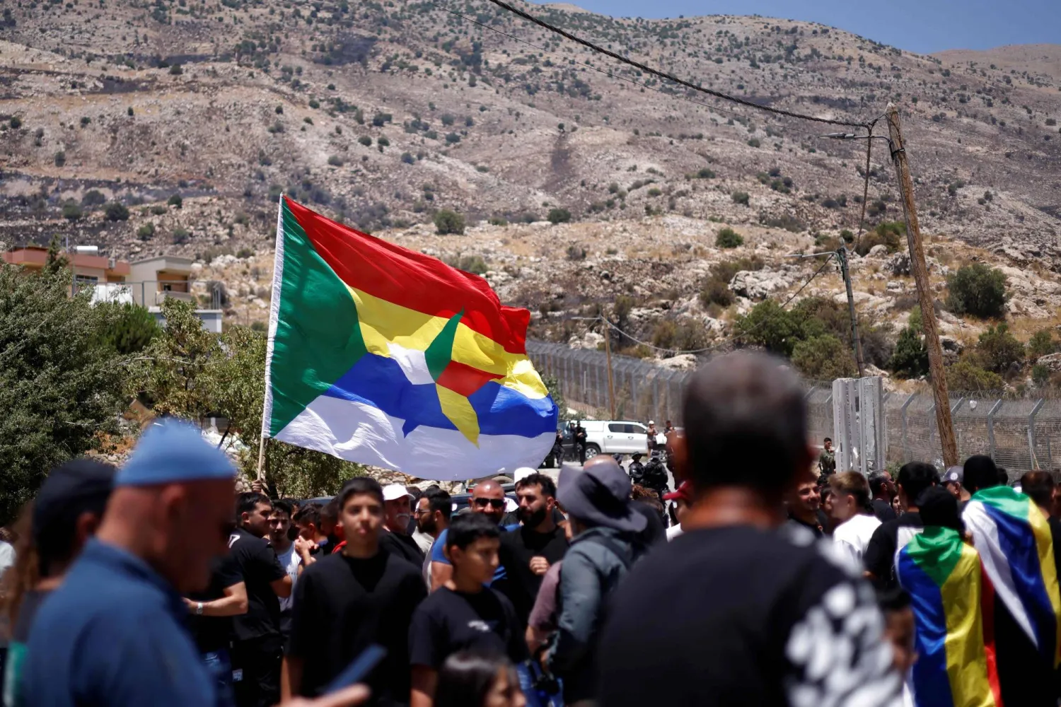 Druze wait near the border fence in the Israeli-annexed Golan Heights village of Majdal Shams, as Syrian Druze who had crossed over the day before, cross back to return to Syrian, on July 17, 2025. (Photo by Jalaa MAREY / AFP)