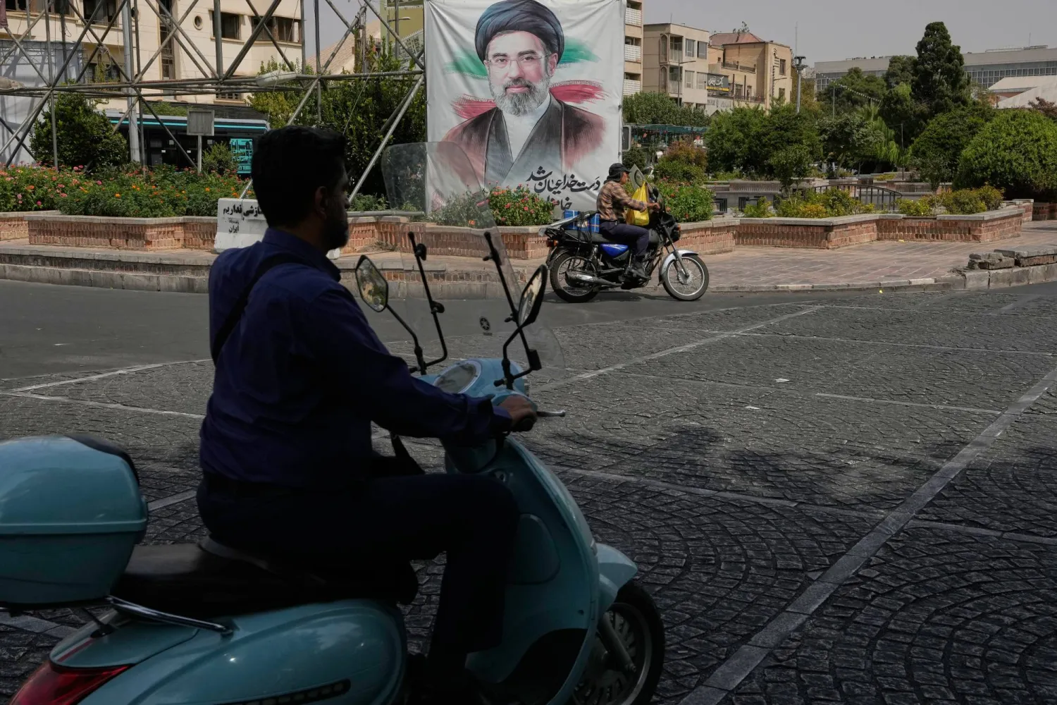  Men drive past a banner showing a portrait of the Iranian Supreme Leader Mojtaba Khamenei, in downtown Tehran, Iran, Monday, Aug. 31, 2026. (AP) 