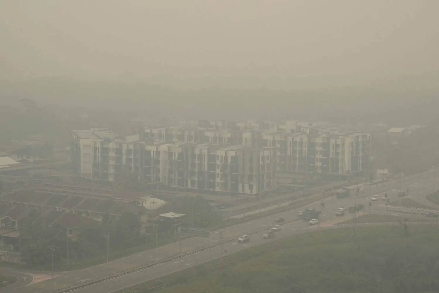 This aerial photo taken from a commercial plane shows haze from Indonesian forest fires blanketing a residential district in Kuching, the capital city of Sarawak state on the island of Borneo on September 5, 2026. (AFP) 