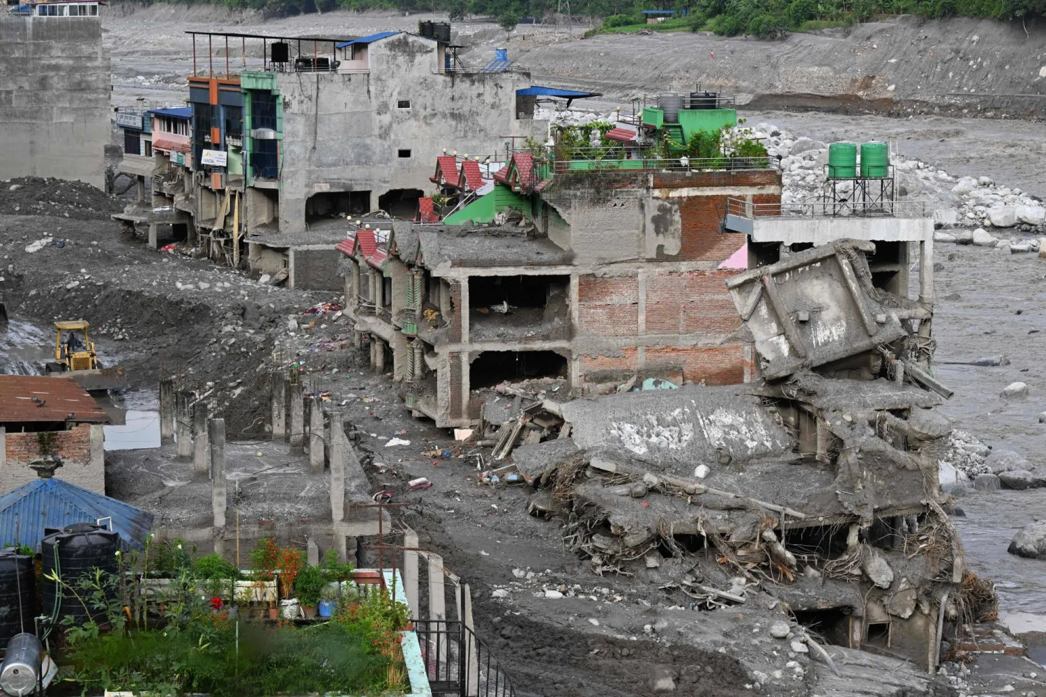 A man using an excavator clears sludge along the Trishuli river in the aftermath of flash floods at Trishuli Bazar in Nepal's Nuwakot district on September 5, 2026. (AFP)
