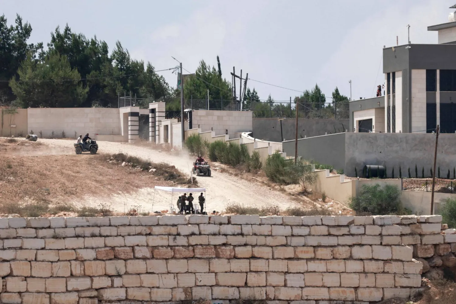 Israeli settlers move around in their off-road vehicles near to the besieged Palestinian houses in Qusra village, south of Nablus, in the occupied West Bank on August 17, 2026. (Photo by Jaafar ASHTIYEH / AFP)