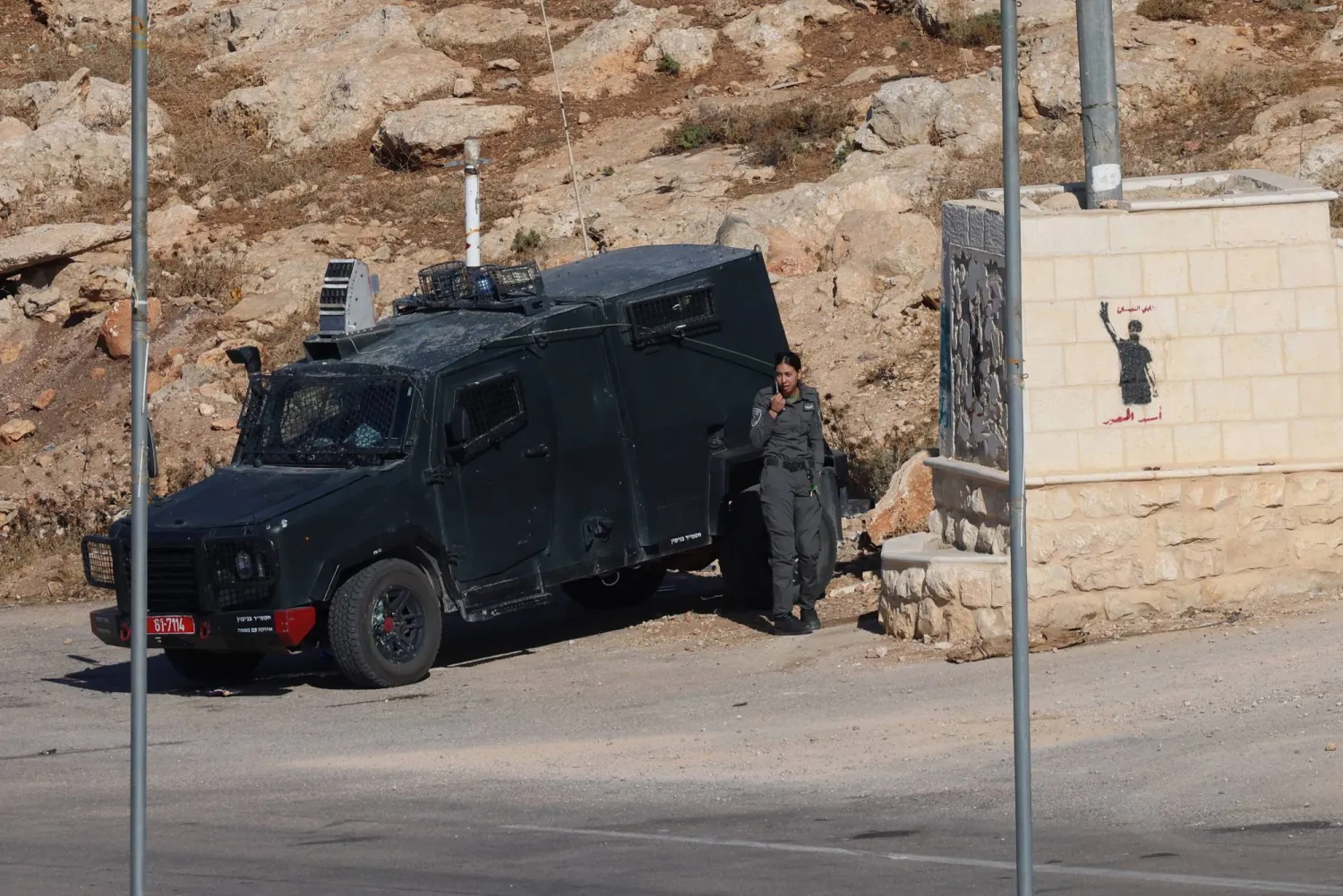 جنود إسرائيليون على متن مركبة عسكرية يراقبون قرب قرية المغير الفلسطينية في الضفة الغربية (إ.ب.أ)