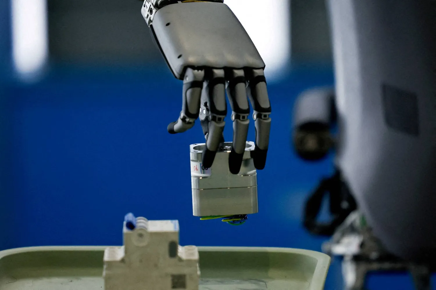 A UBTech humanoid robot, Walker S, picks up an object operated by a staff member, during a demonstration simulating a factory's assembly line, at the robotics exhibition center Robot World, during an organized media tour to the Beijing Robotics Industrial Park, in Beijing Economic-Technological Development Area, also known as Beijing E-Town, in China May 16, 2025. (Reuters)