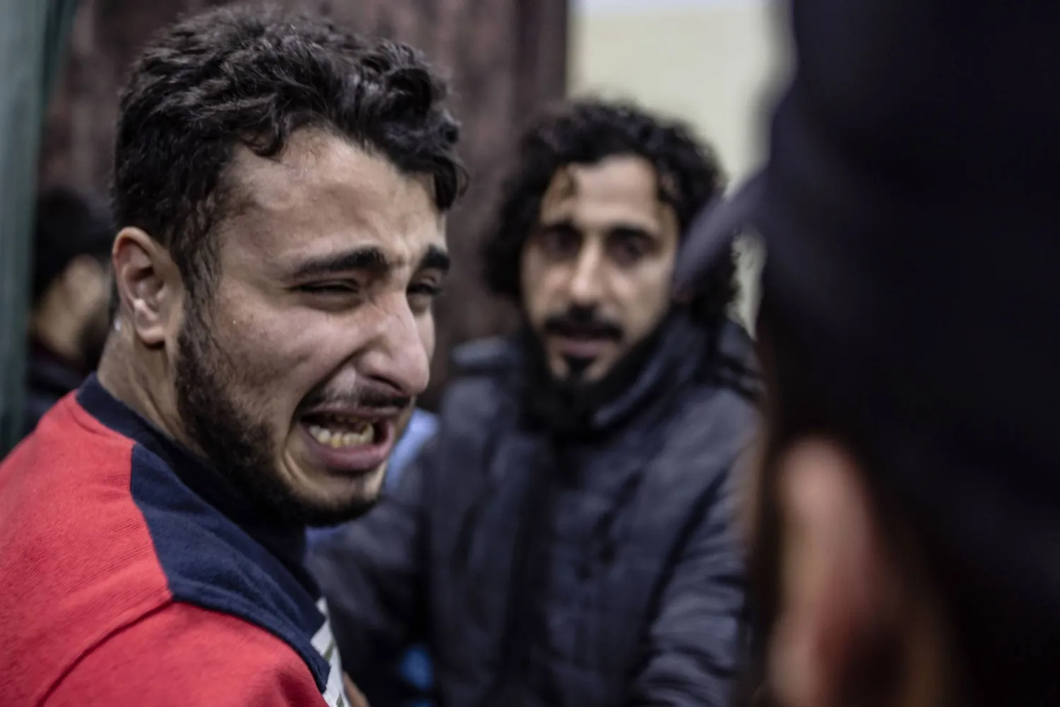 رجل يبكي شقيقه المصاب من قصف مدفعي عنيف لقوات النظام على إدلب ديسمبر 2023 (د.ب.أ)