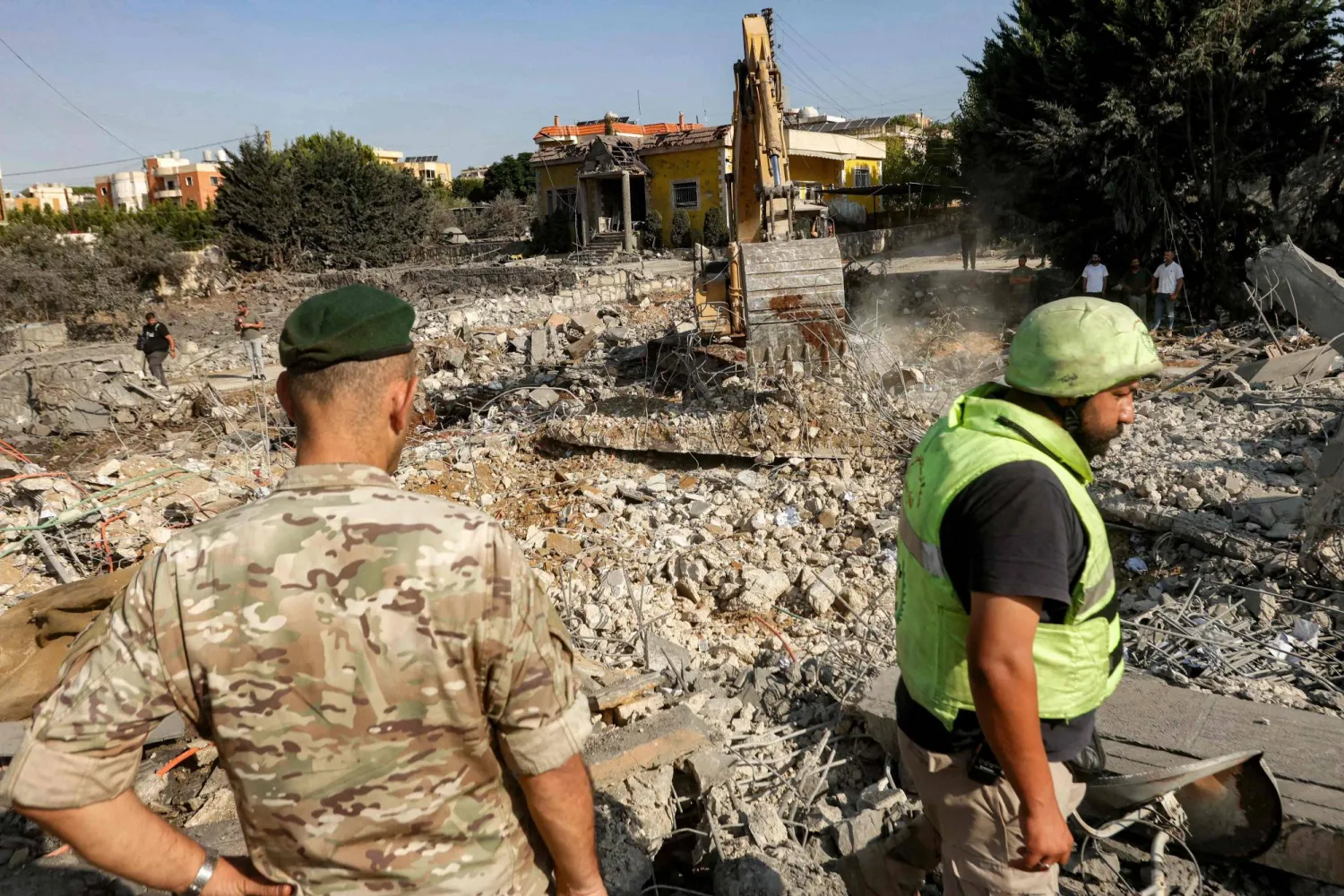 جندي لبناني ومتطوع بالدفاع المدني يشرفان على إزالة الركام بمبنى دمرته غارة إسرائيلية في بلدة كفر رمان جنوب لبنان (أ.ف.ب)