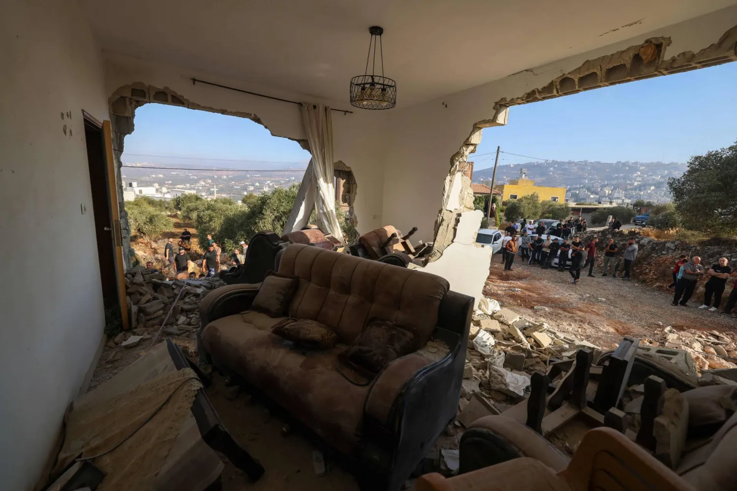 Palestinians inspect a family home destroyed by the Israel army following a military operation after a Palestinian man barricaded himself inside the house in the Israel-occupied West Bank village of Aqraba, south of the city of Nablus on September 8, 2026. (Photo by JAAFAR ASHTIYEH / AFP)