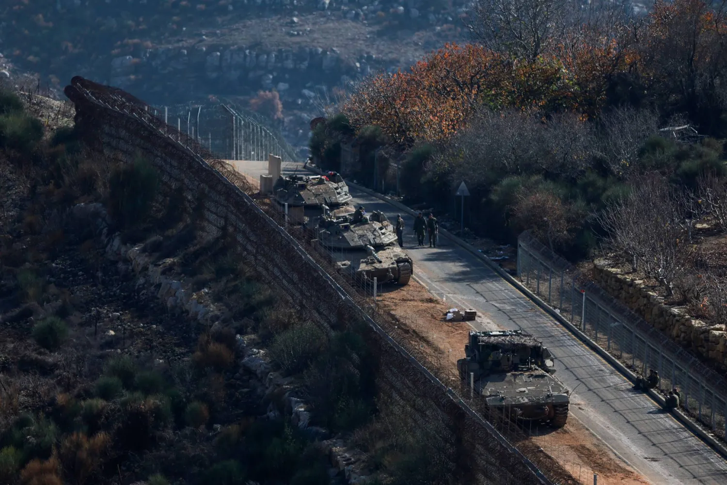 Israeli soldiers stand next to military vehicles as they gather near the ceasefire line between Syria and the Israeli-occupied Golan Heights, December 9, 2024. (Reuters)