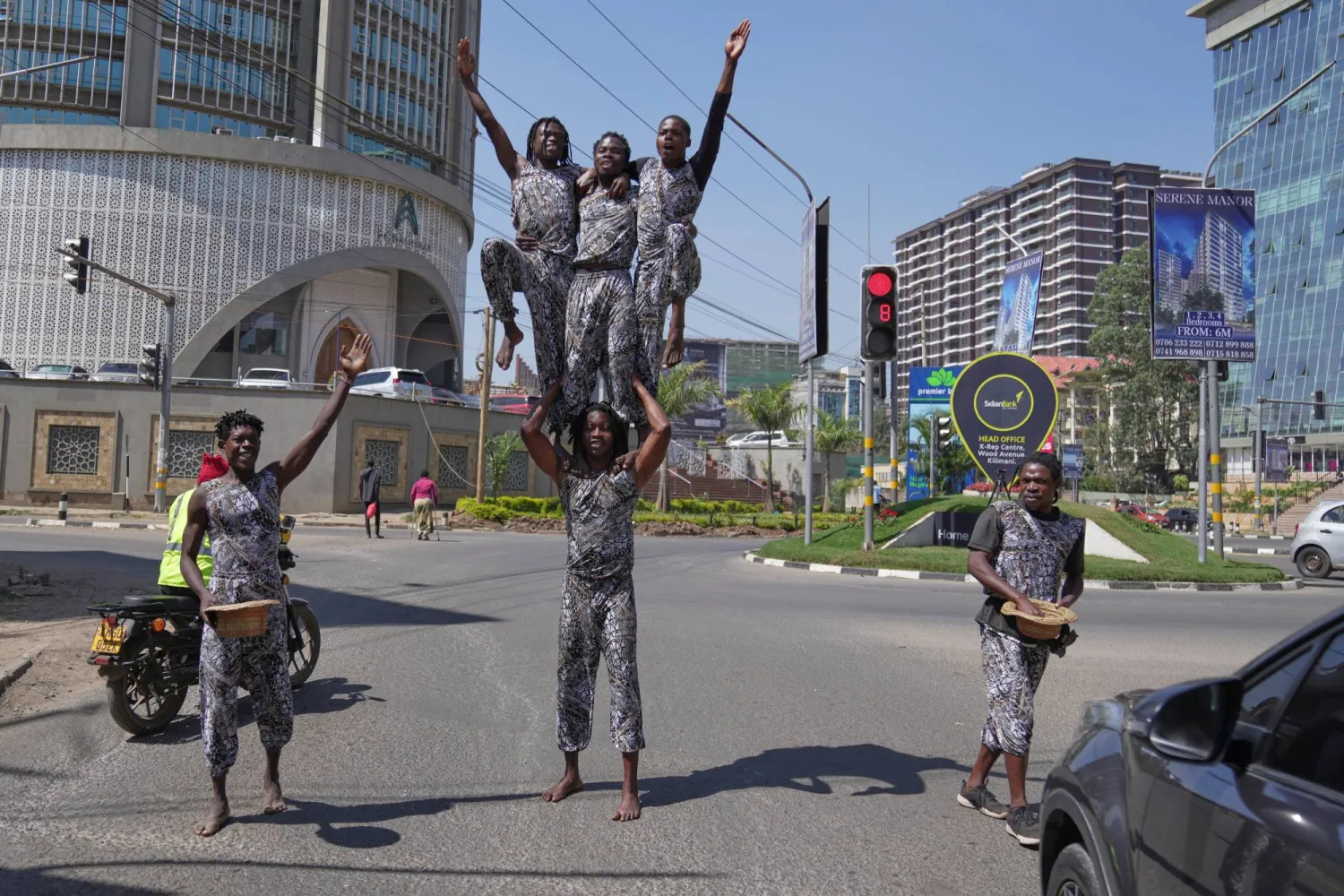 Acrobats perform in a busy street amid by traffic in Nairobi, Kenya, Wednesday, Aug. 26, 2026. (AP)