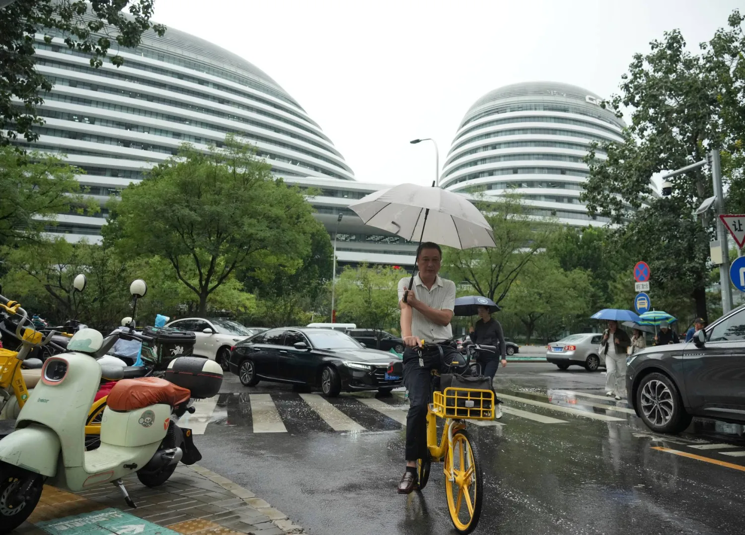 A man rides a bicycle in the rain in Beijing, Tuesday, Sept. 8, 2026. (AP)