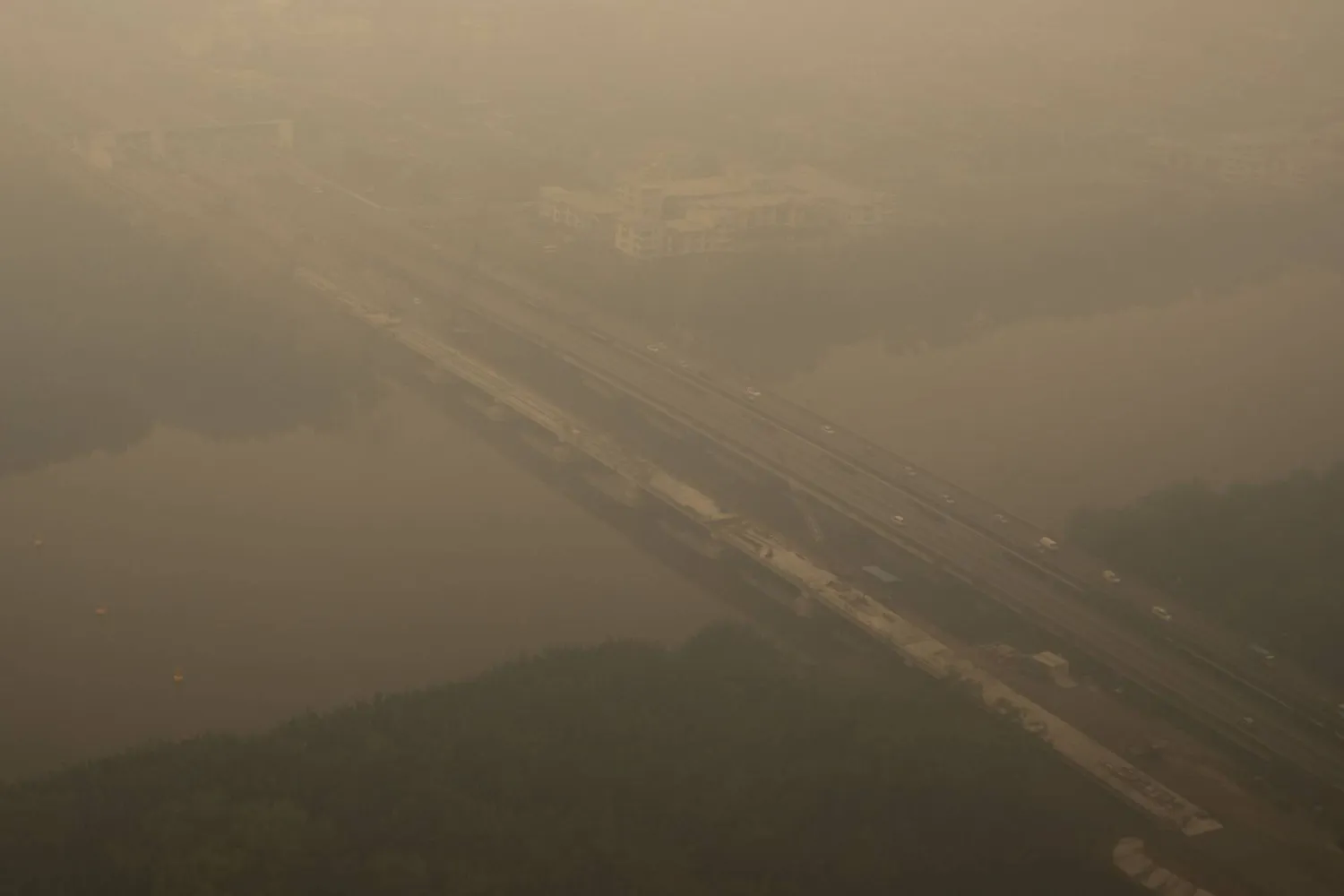 This aerial photo taken from a commercial aircraft shows haze from Indonesian forest fires blanketing a bridge in Kuching, the capital city of Malaysia's Sarawak state on the island of Borneo on September 5, 2026. (AFP)