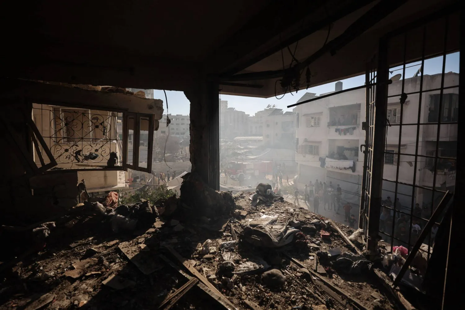 Palestinians look on from the street at the damage to a house that was hit by an Israeli strike following an evacuation warning in the Al-Rimal neighborhood of Gaza City on September 8, 2026. (AFP)