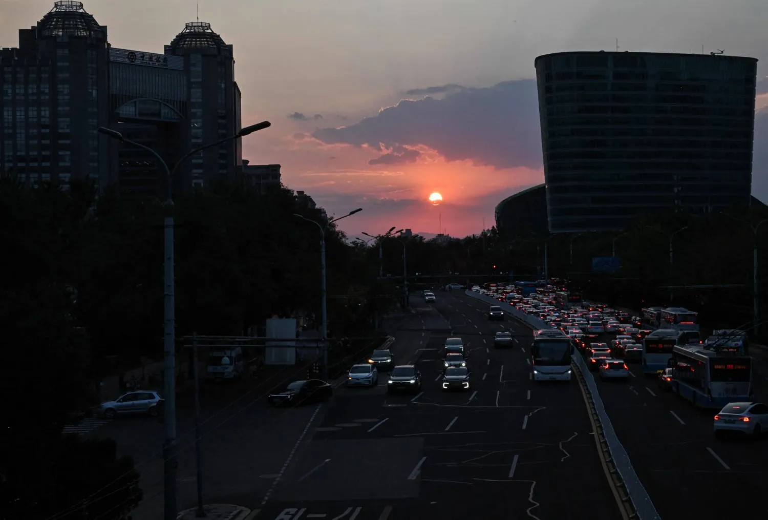 People commute as the sun sets in Beijing on September 12, 2026. (AFP)