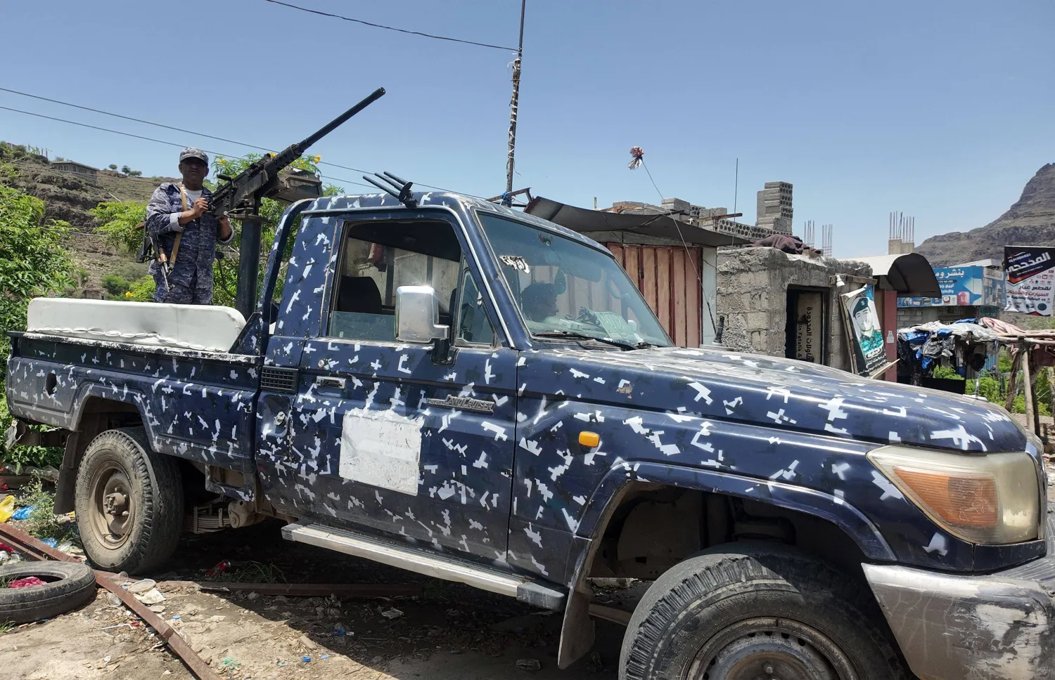 A member of the Yemeni government forces, including National Army and Taiz Axis forces, mans a turret mounted on the back of a pickup truck at a checkpoint along the al-Kadha frontline west of Taiz in western Yemen on September 13, 2026. (AFP) 