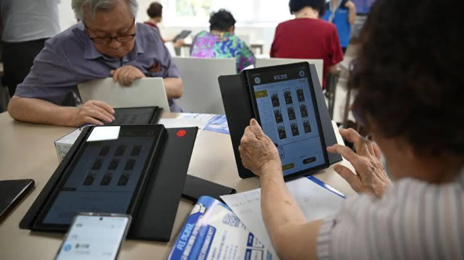 Elderly people using tablets during a government-organized digital survival training course at a senior community center in Suwon. Jung Yeon-je / AFP
