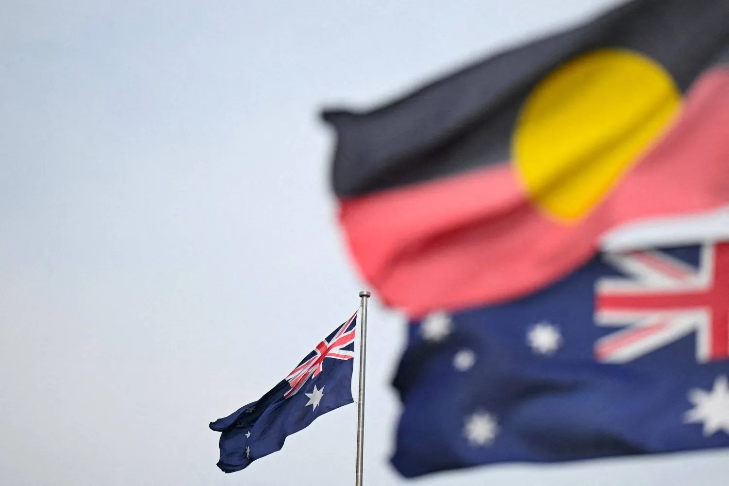 An Australian and an Aboriginal flag are seen in Canberra, Australia Wednesday, August 30, 2023. (AAP Image/Lukas Coch via Reuters)