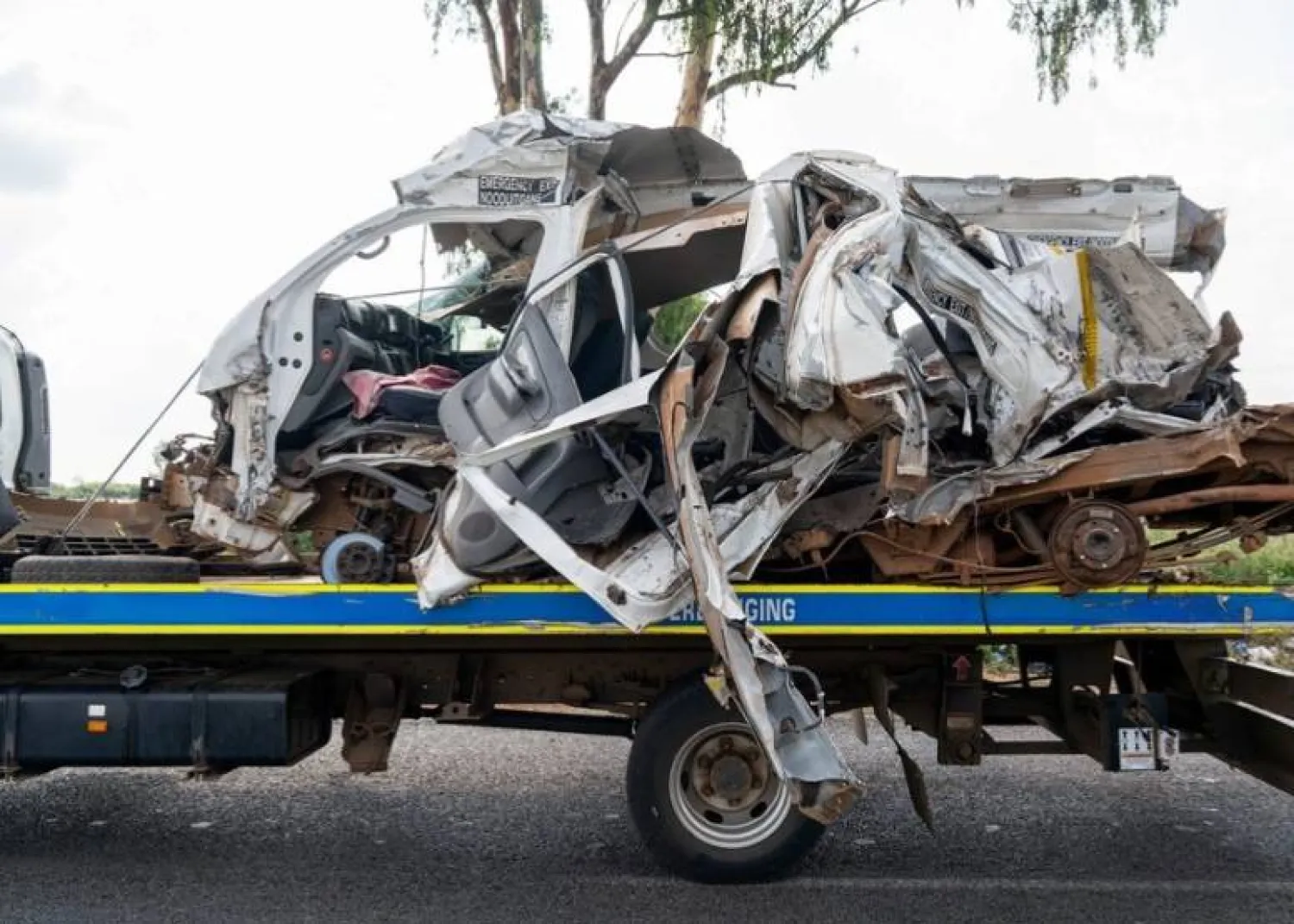 The remains of a mini bus taxi on a police tow truck at the scene of a fatal crash of 13 schoolchildren who perished ​when their minibus collided with a truck, in Johannesburg, South Africa, January 19, 2026. REUTERS/Shiraaz Mohamed