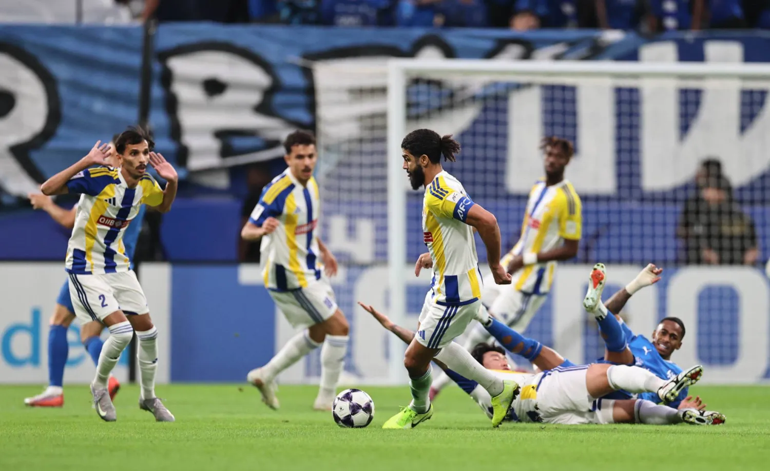 هيون يسقط متعثرا بعد احتكاكه بسامر فيل لاعب الهلال (تصوير: صالح الغنام)