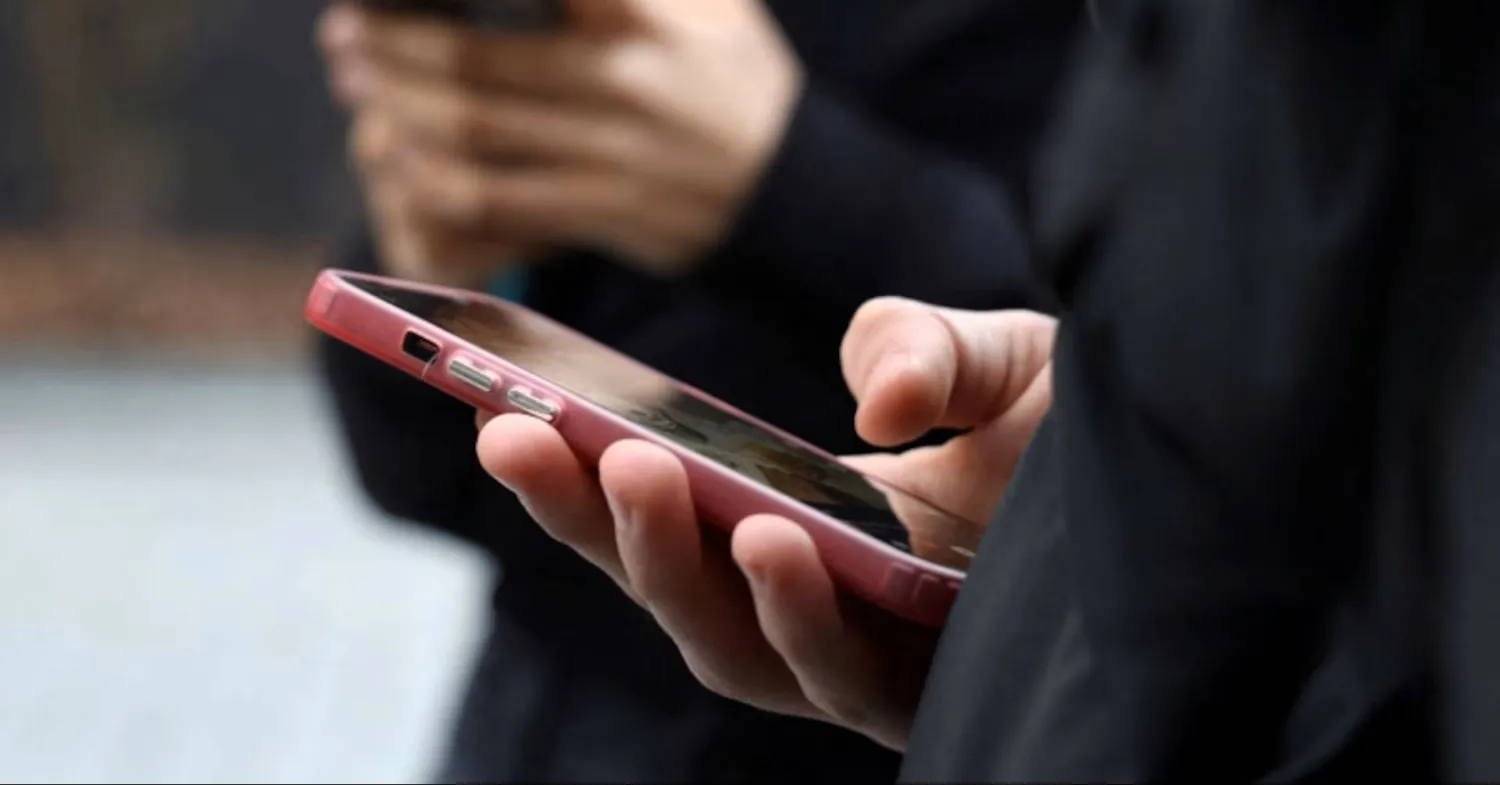 Teenagers look at their mobile phone screens during an interview with Reuters about the bill aimed at banning the use of social networks for those under 15 and mobile phones in high schools from the start of the 2026 school year, in Paris, France, February 20, 2026. (Reuters)