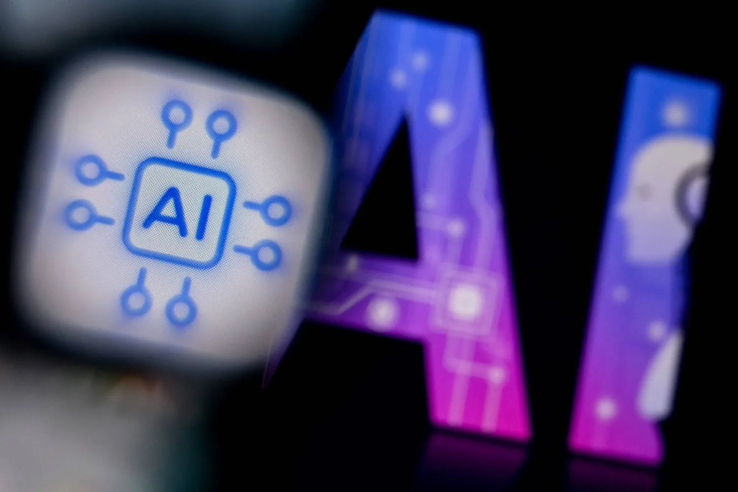 A photo taken on February 26, 2024 shows the logo of the Artificial Intelligence chat application on a smartphone screen (L) and and the letters AI on a laptop screen in Frankfurt am Main, western Germany. (AFP)