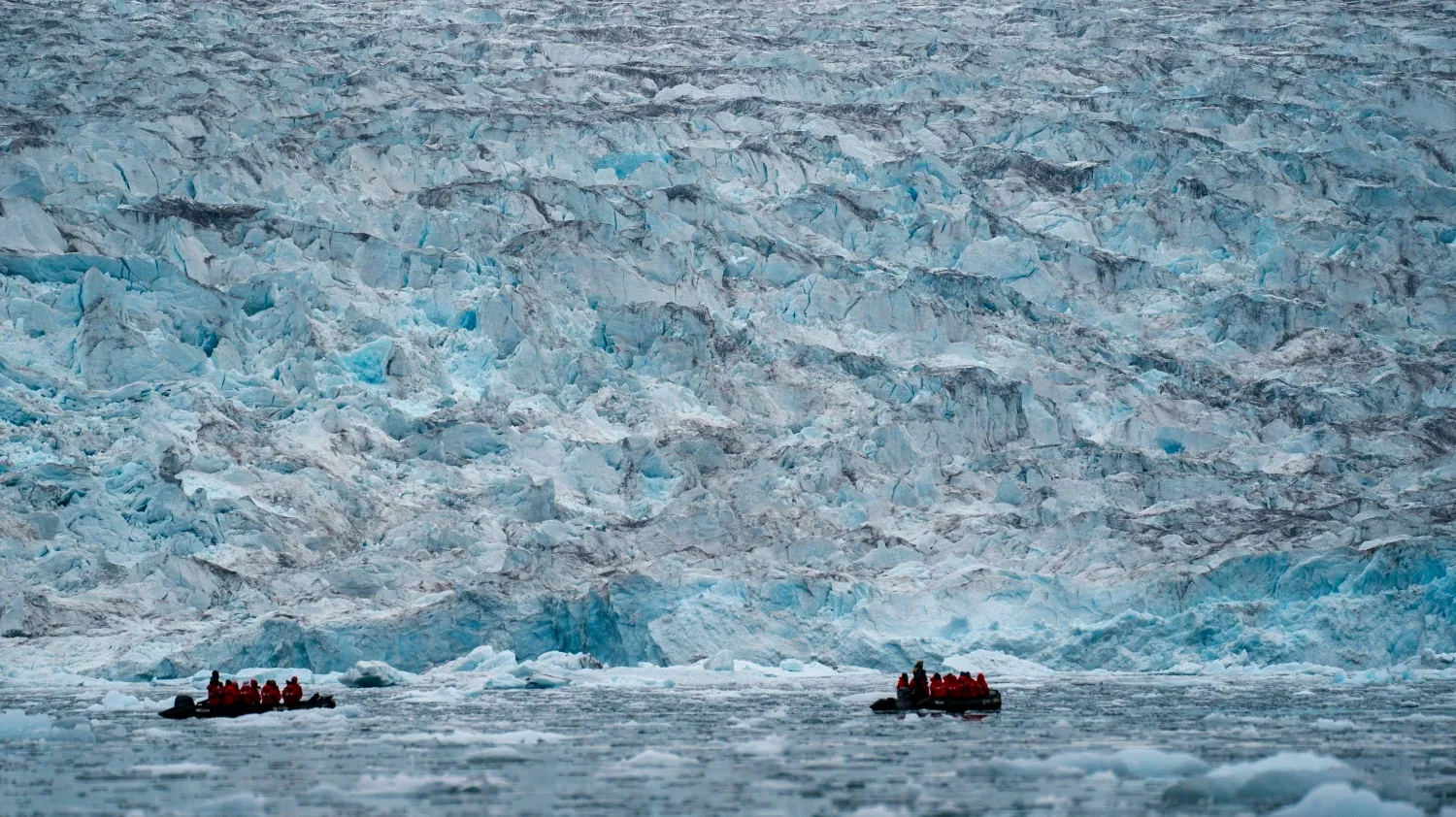 Two groups from the Poseidon Expeditions tour company look at a glacier in the Scoresby Sund, Sept. 7, 2023, in Greenland. (AP)